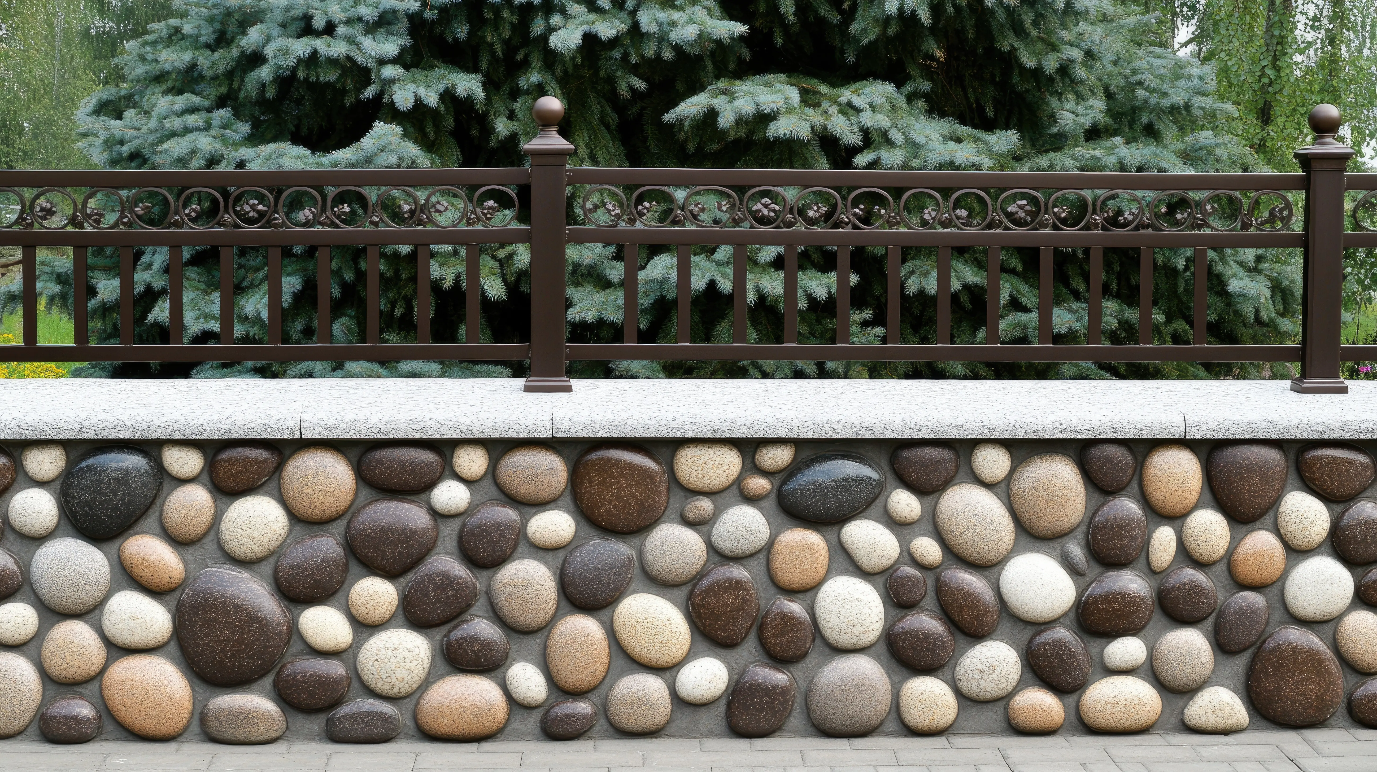In bright daylight, a sturdy brown metal fence capped with vibrant green foliage and set on a stone base forms a serene residential boundary.